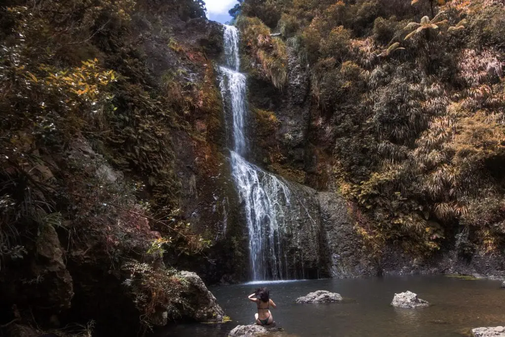 Best West Auckland Walks: Sitting at the bottom of Kitekite Waterfall