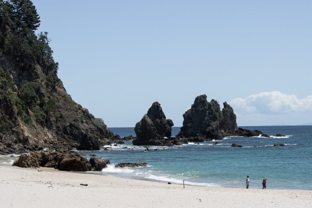 Best Coromandel Beaches. Photograph of the waves crashing against the rocks at Otama Beach, Coromandel