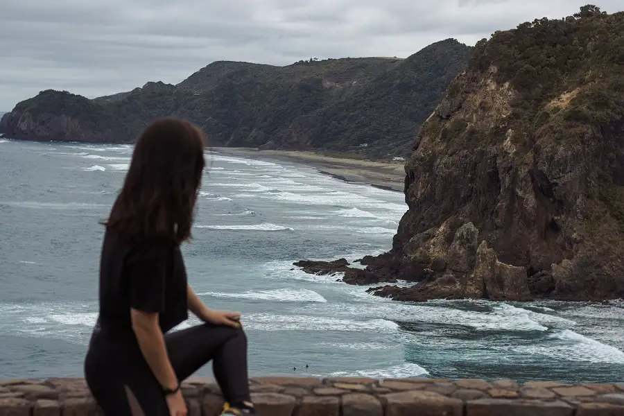 Fun things to do in Auckland: Female overlooking Piha beach