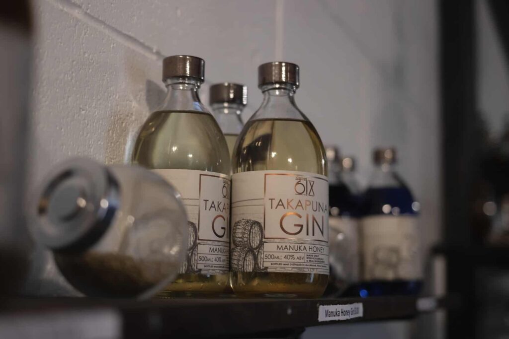 Bottles of Takapuna Gin sit on a shelf against a wall at Auckland Gin Distillery