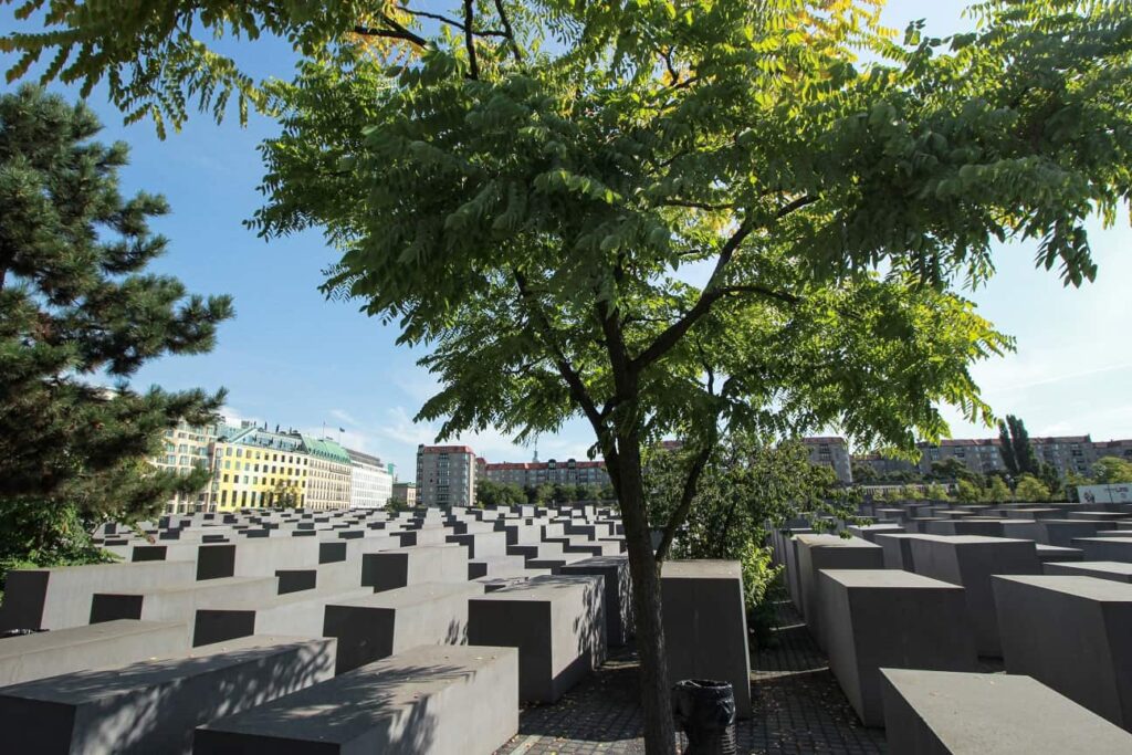 A photo of the top of the Memorial to the Murdered Jews statues in Belin. A green tree grows within the memorial.