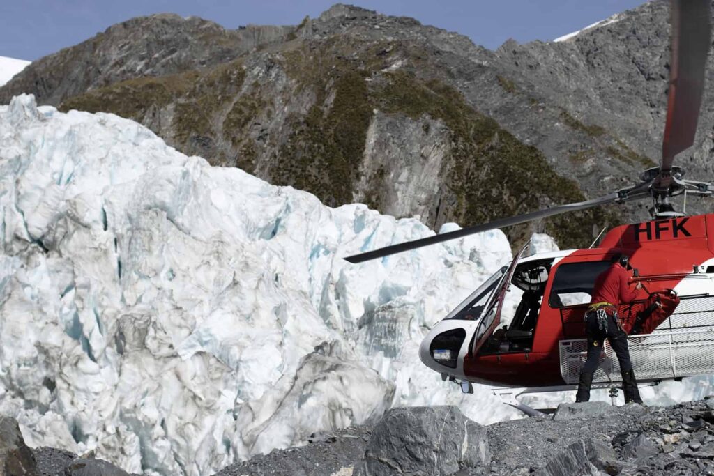 Franz Josef Glacier Hike: A helicopter sitting on the Franz Josef glacier unloading people for Franz Josef Glacier heli hike.