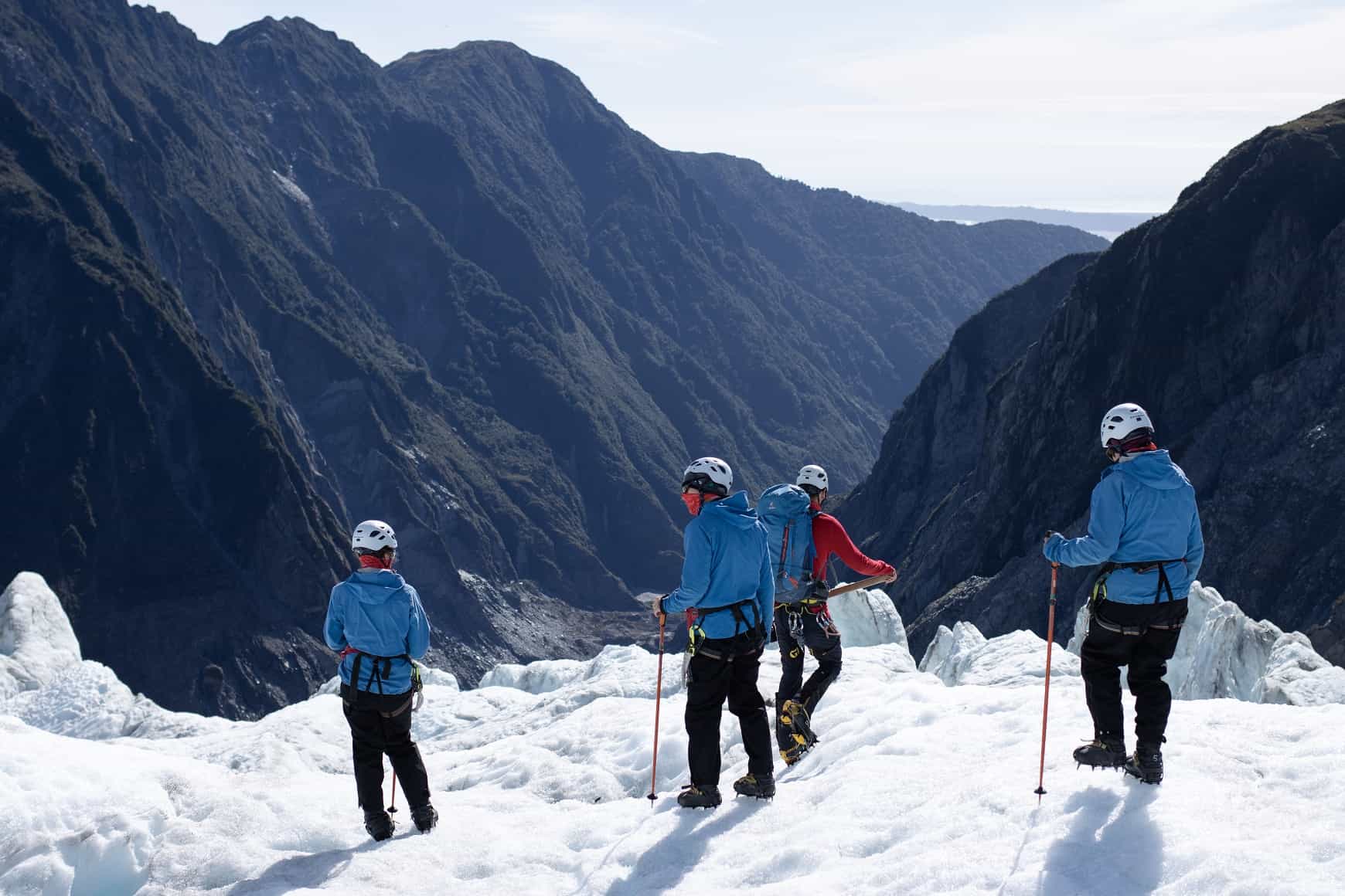 4 people in snow hiking gear standing on the ice shelf during a heli hike to Franz Josef glacier.