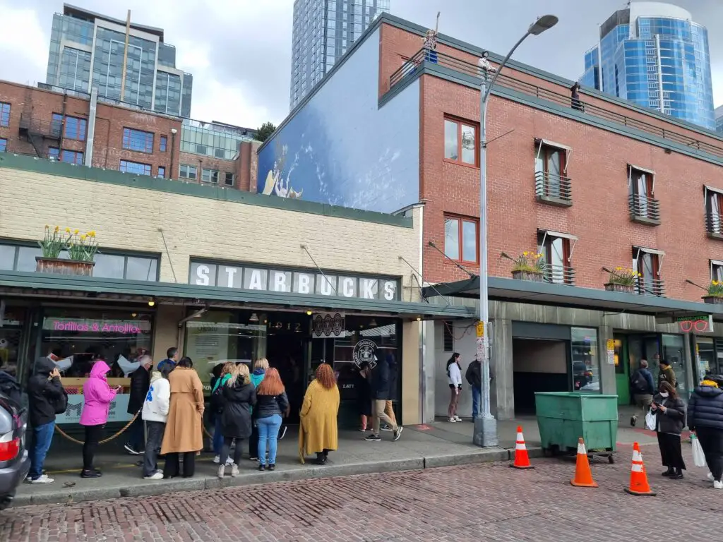 Photo of the first Starbucks in Seattle. Queue of people lining outside the door