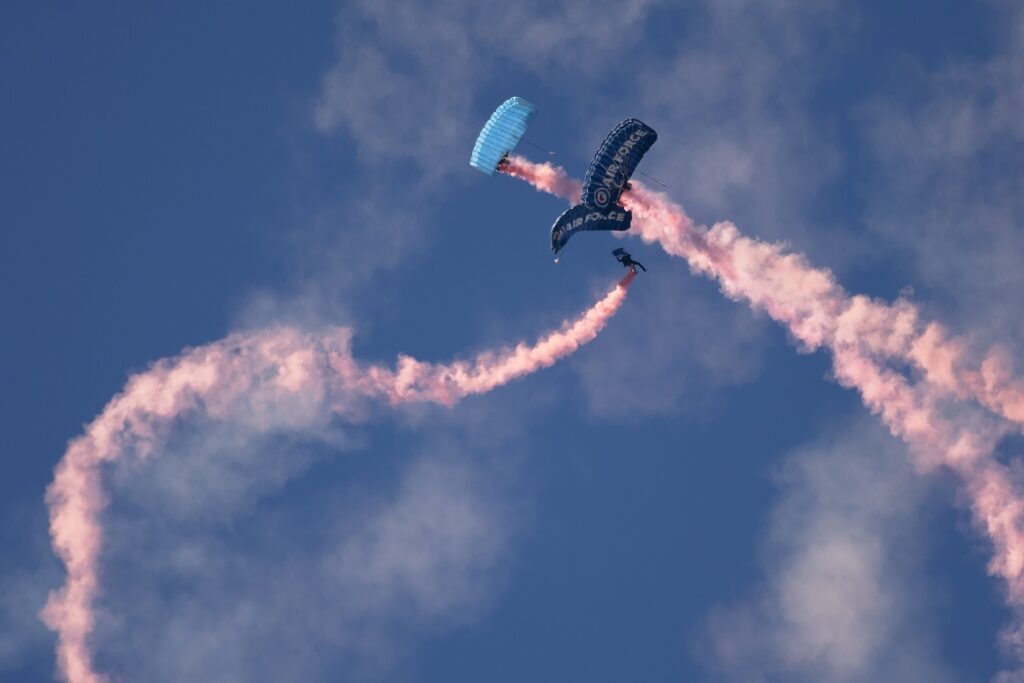 New Zealand Travel Guide: 3 New Zealand Airforce personnel parachuting during Warbirds over Wanaka airshow.