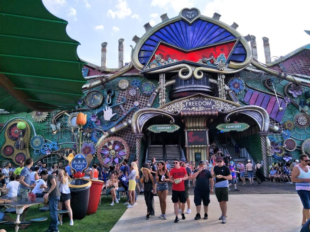 Tomorrowland Belgium: Survival Guide 2025 7 A group of people walking towards the very colourful 'Freedom' stage at Tomorrowland, Belgium