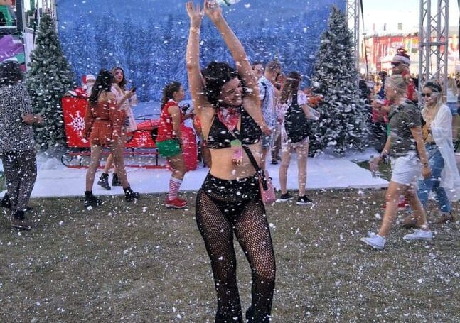 Ultra Music Festival Croatia 10 Woman wearing a black bralette and fishnet pants dancing in fake snow at Sziget music festival
