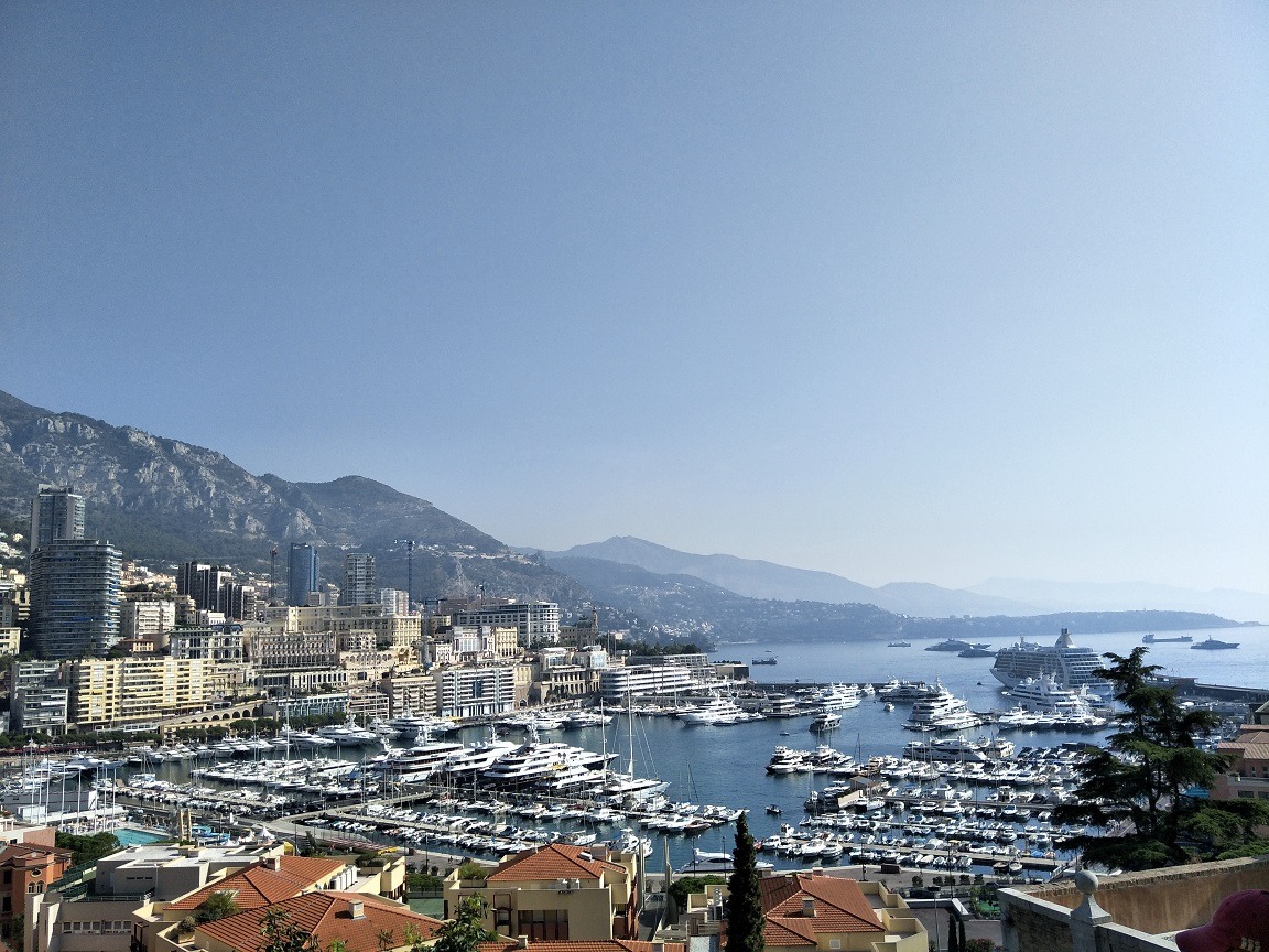A view of Monaco which shows the port with hundreds of yachts and tall buildings in the distance.