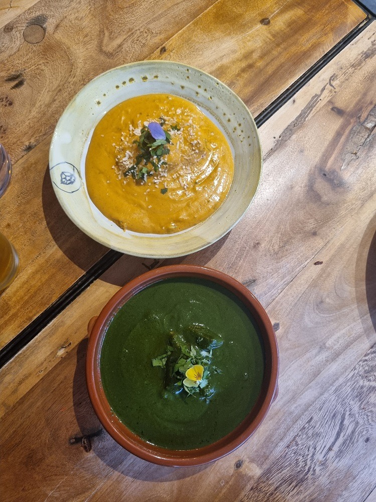 7 of The Best Indian Restaurants in Auckland 8 Two bowls of curry; one is a yellow curry garnished with an edible flower, the other one is a lamb saagwala also garnished with an edible flower. This is served at 3 Nutmegs Indian restaurant in Auckland.