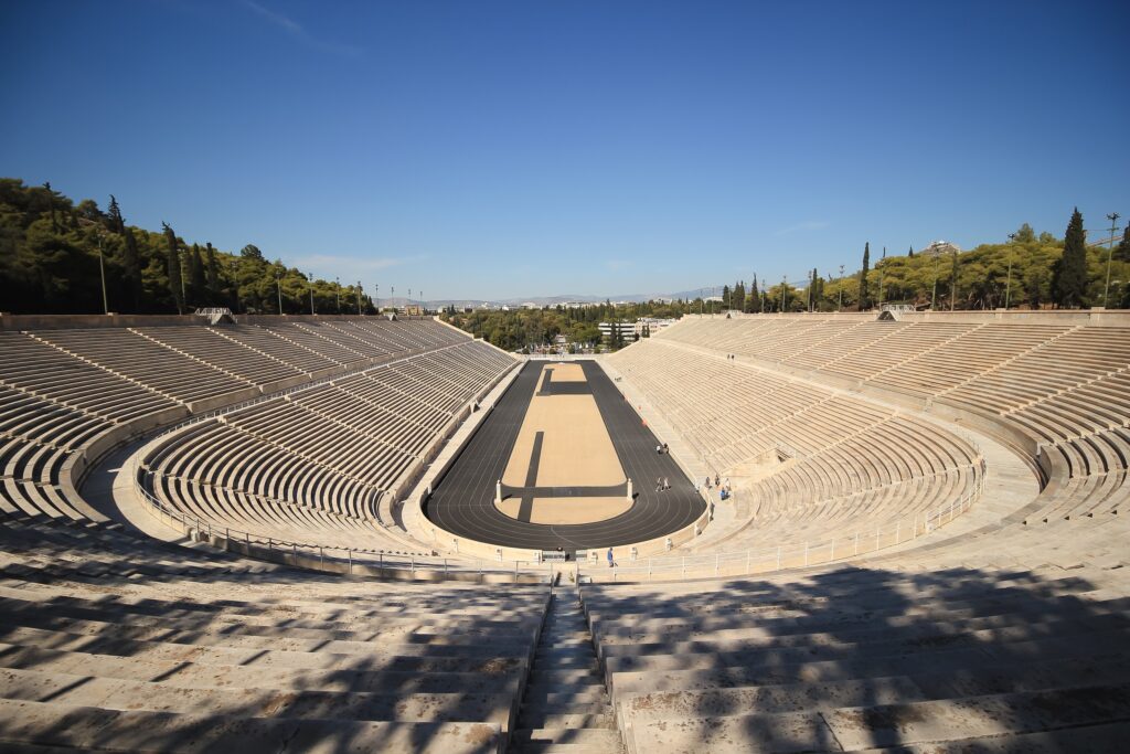 A wide angle shot of the Panathenic stadium in Athens, Greece. A running track is in the center of the stadium.