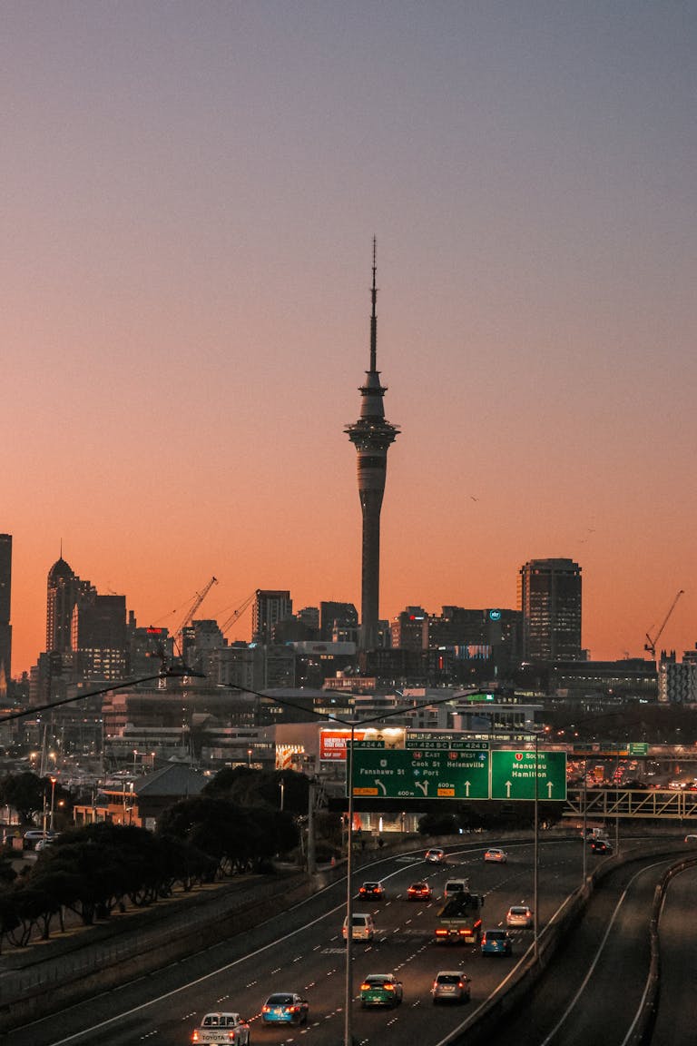 A stunning view of Auckland Harbour Bridge with a warm sunrise backdrop.