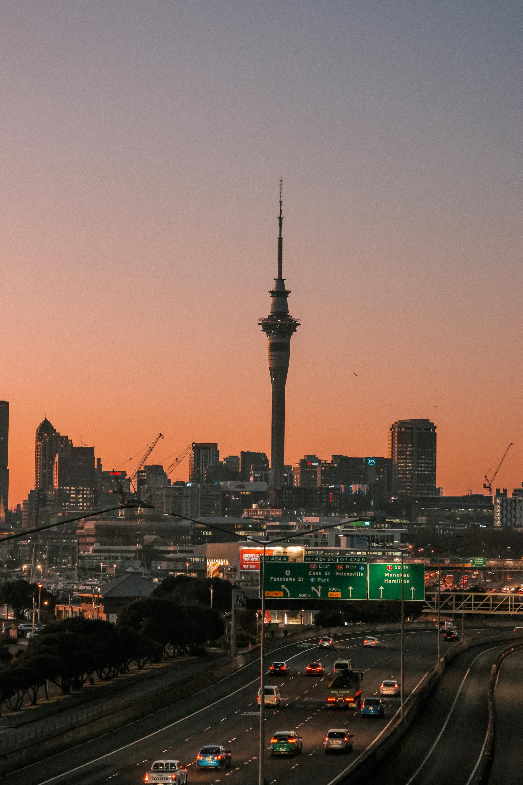 A stunning view of Auckland Harbour Bridge with a warm sunrise backdrop.