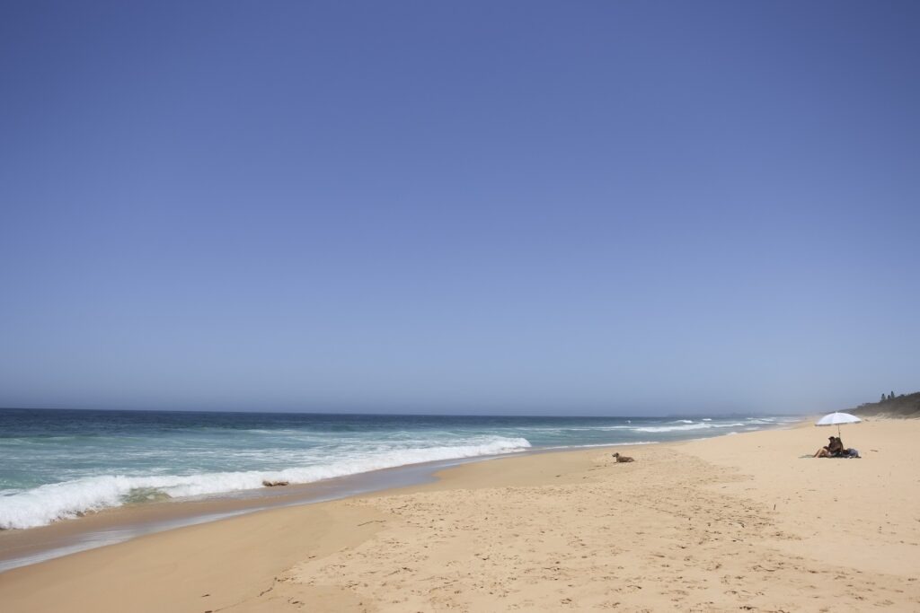 Road trips from Brisbane: A beach on the Sunshine Coast with rolling waves and white sand.