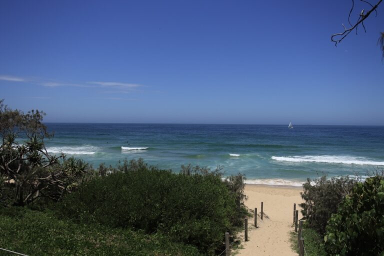 Road trips from Brisbane: A beach on the Sunshine Coast with rolling waves and white sand.