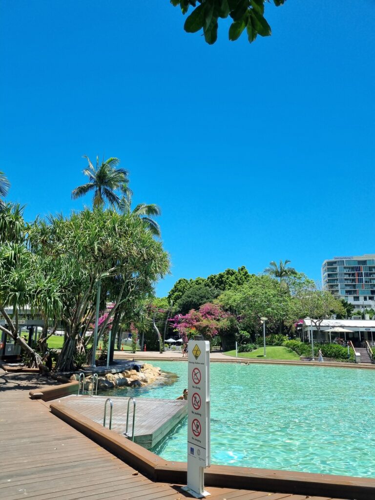 Brisbane Weekend Itinerary: This shows a section of Streets Beach in Brisbane's Southbank. Clear blue waters in a man made lagoon surrounded by sand,