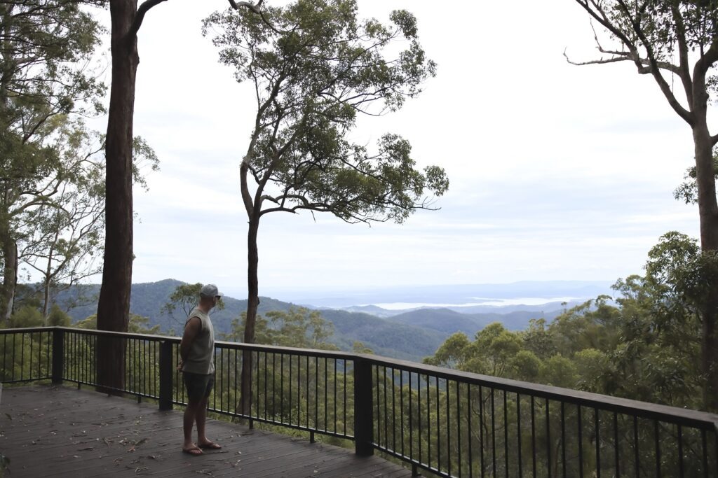 A man standing on a large wooden platform lookout in Brisbane, Australia
