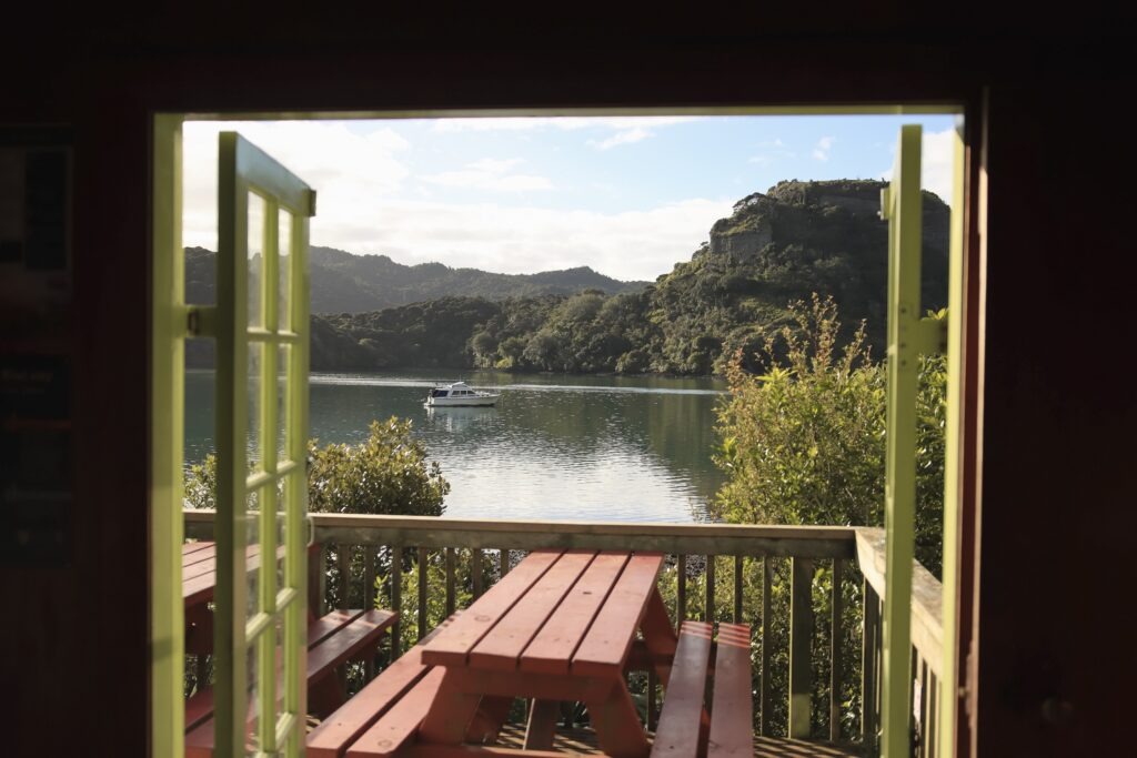 Dukes Nose Hiking Trail Guide – Best Hikes in Northland Photo from inside Lane Cove Hut overlooking the Whangaroa Harbour