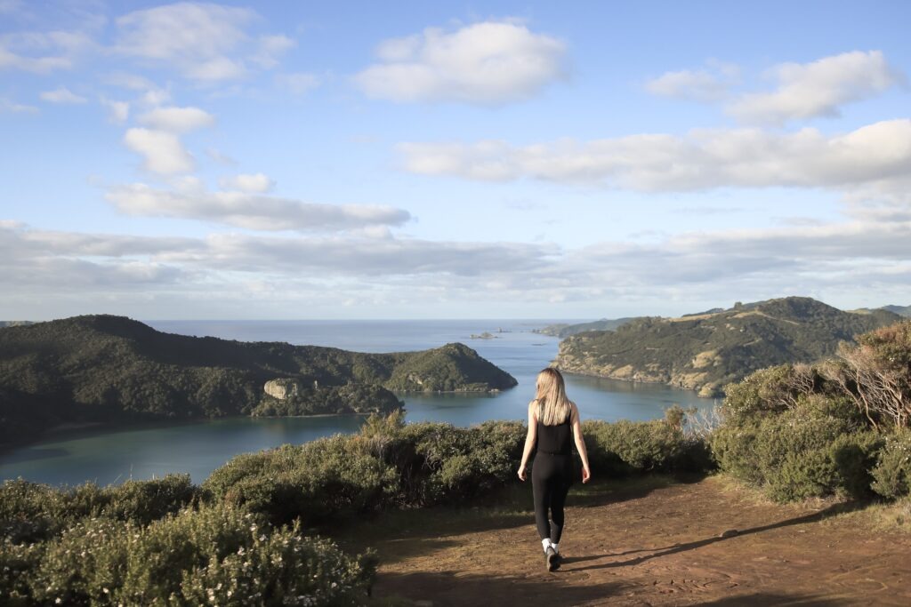 Dukes Nose Hiking Trail Guide – Best Hikes in Northland Woman walking towards the view at Dukes Nose hiking trail in Northland